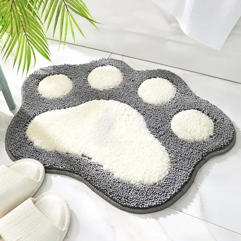 Tapis de bain gris et blanc avec empreinte de patte et texture moelleuse.