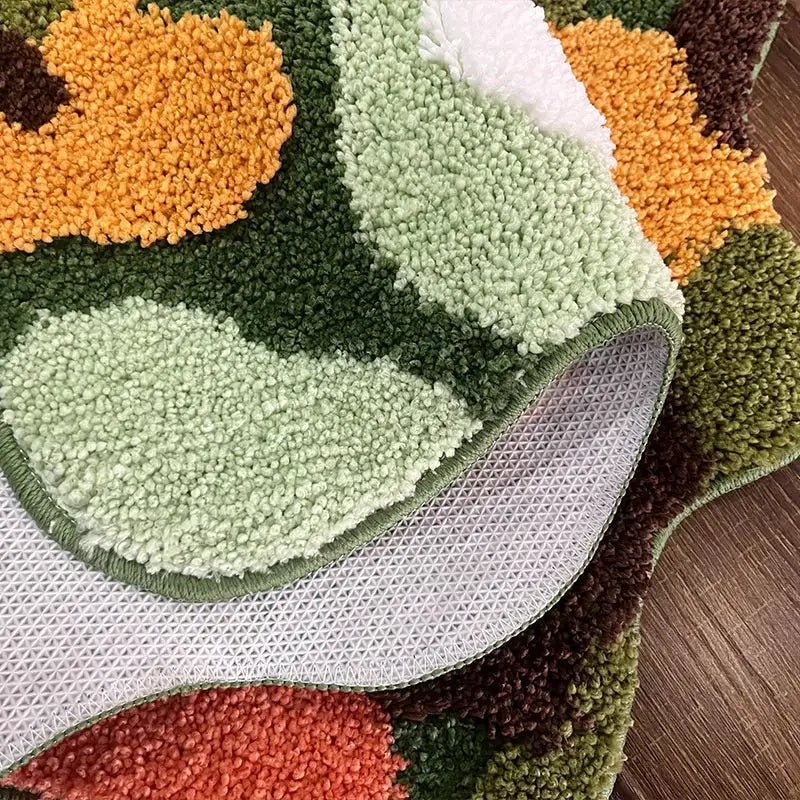 Tapis de bain floral vert et orange avec une moquette texturée, probablement fabriqué en microfibre ou un matériau similaire.