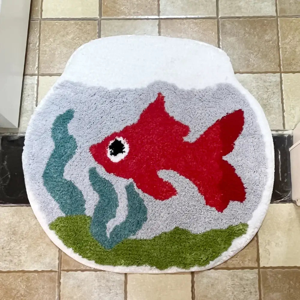 Tapis de bain poisson rouge avec poissons rouges vibrants, accents d’algues vertes et design d’eau grise sur fond blanc.