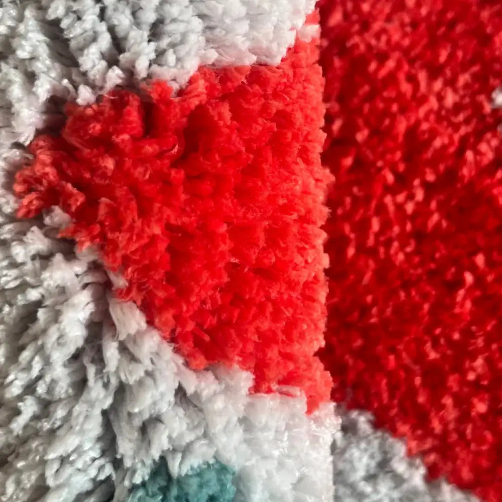 Tapis de bain texturé rouge et blanc avec un matériau doux et moelleux.
