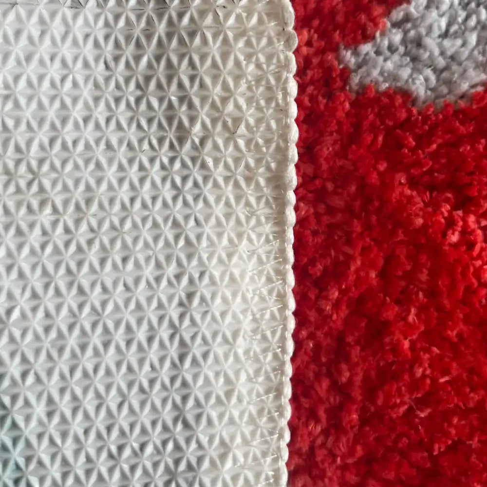 Tapis de couloir texturé rouge et blanc avec motif géométrique, probablement en nylon ou polyester.