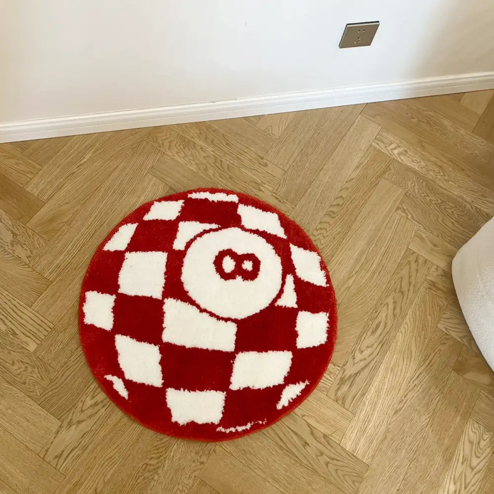 Tapis circulaire à carreaux rouges et blancs avec un numéro huit brodé proéminent au centre.