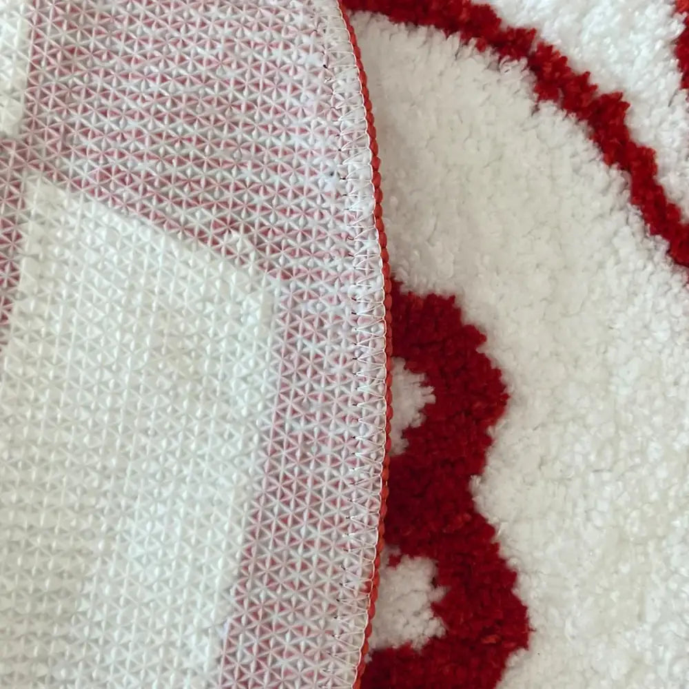 Tapis texturé blanc et rouge avec une surface moelleuse et hirsute.