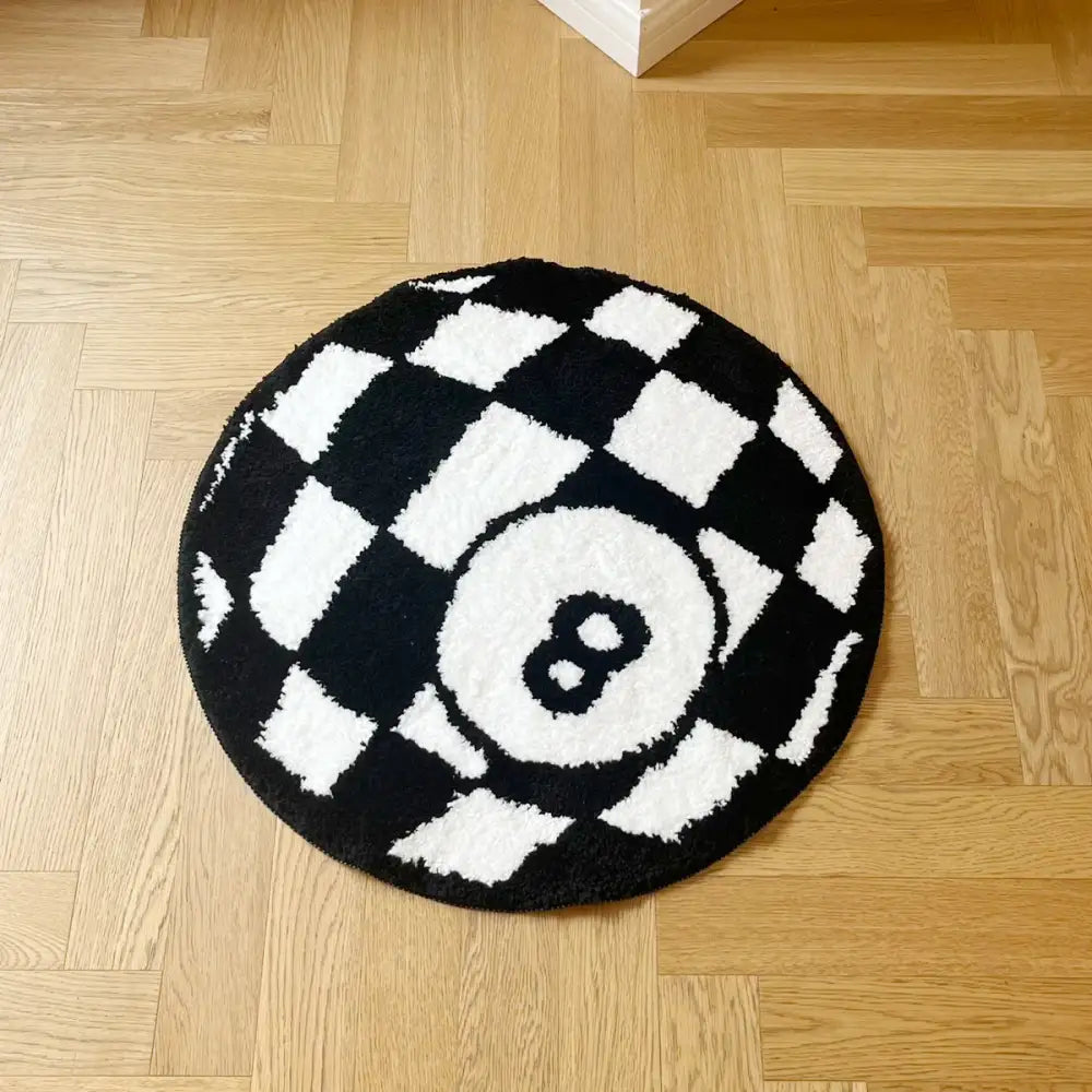 Tapis circulaire à damier noir et blanc arborant un design proéminent du chiffre huit blanc au centre.