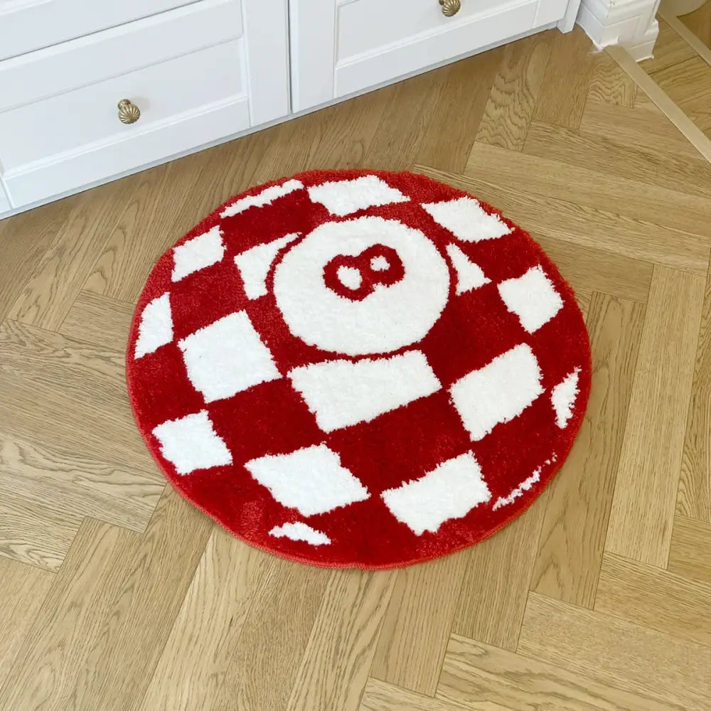 Tapis circulaire à carreaux rouges et blancs orné d’un design brodé du chiffre huit proéminent.