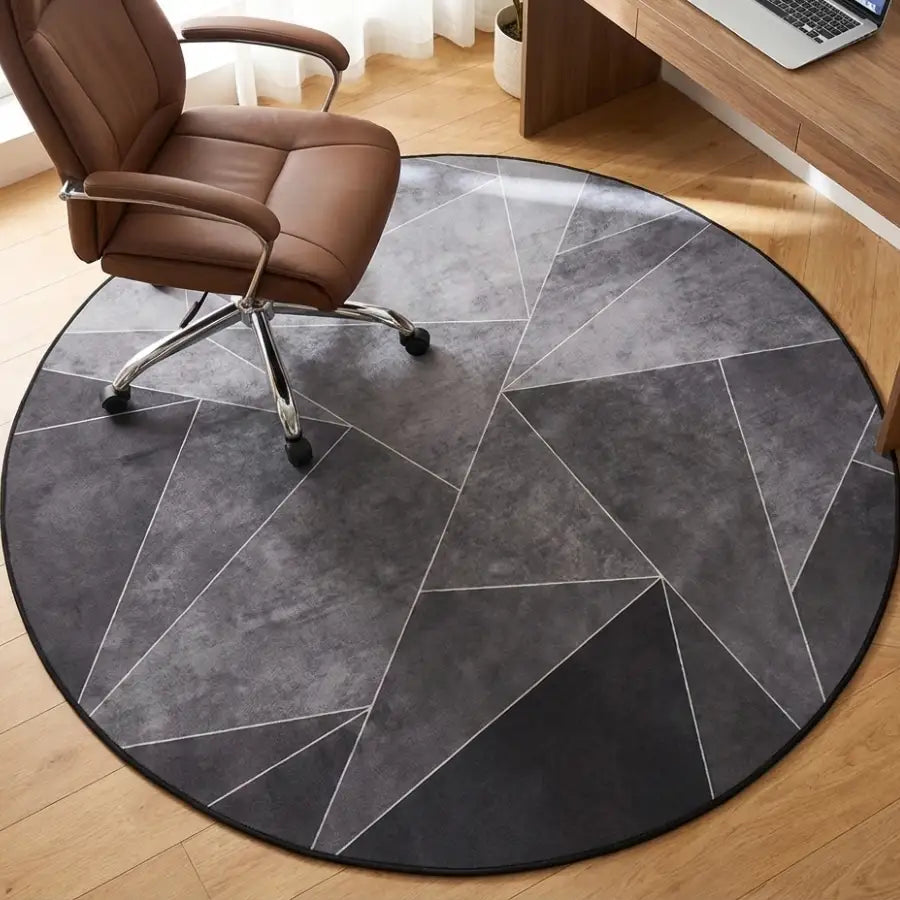 Tapis géométrique circulaire gris avec des lignes blanches formant des motifs triangulaires.