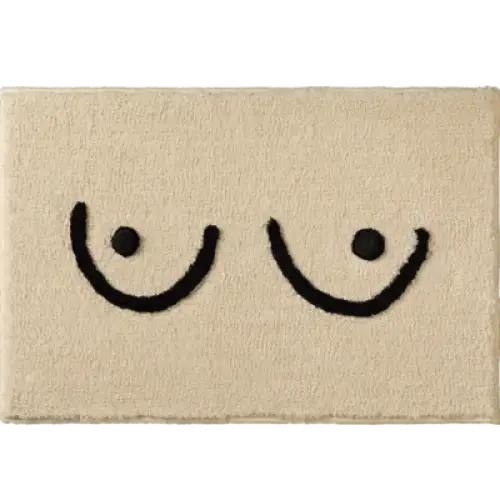 Tapis de bain en peluche beige orné d’un simple motif brodé noir représentant deux seins stylisés.