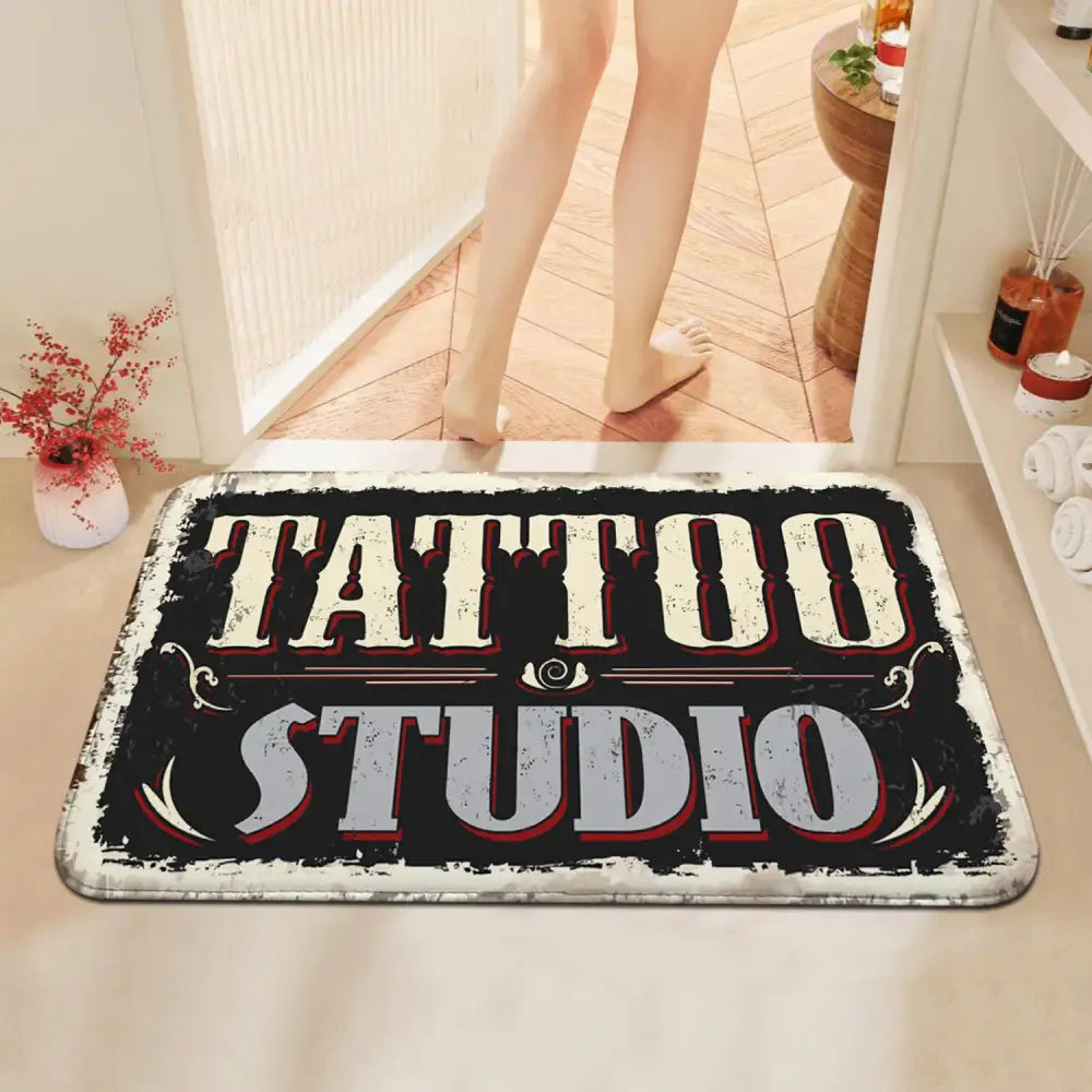 Tapis ’studio de tatouage’ style vintage noir, blanc et rouge avec bords usés.
