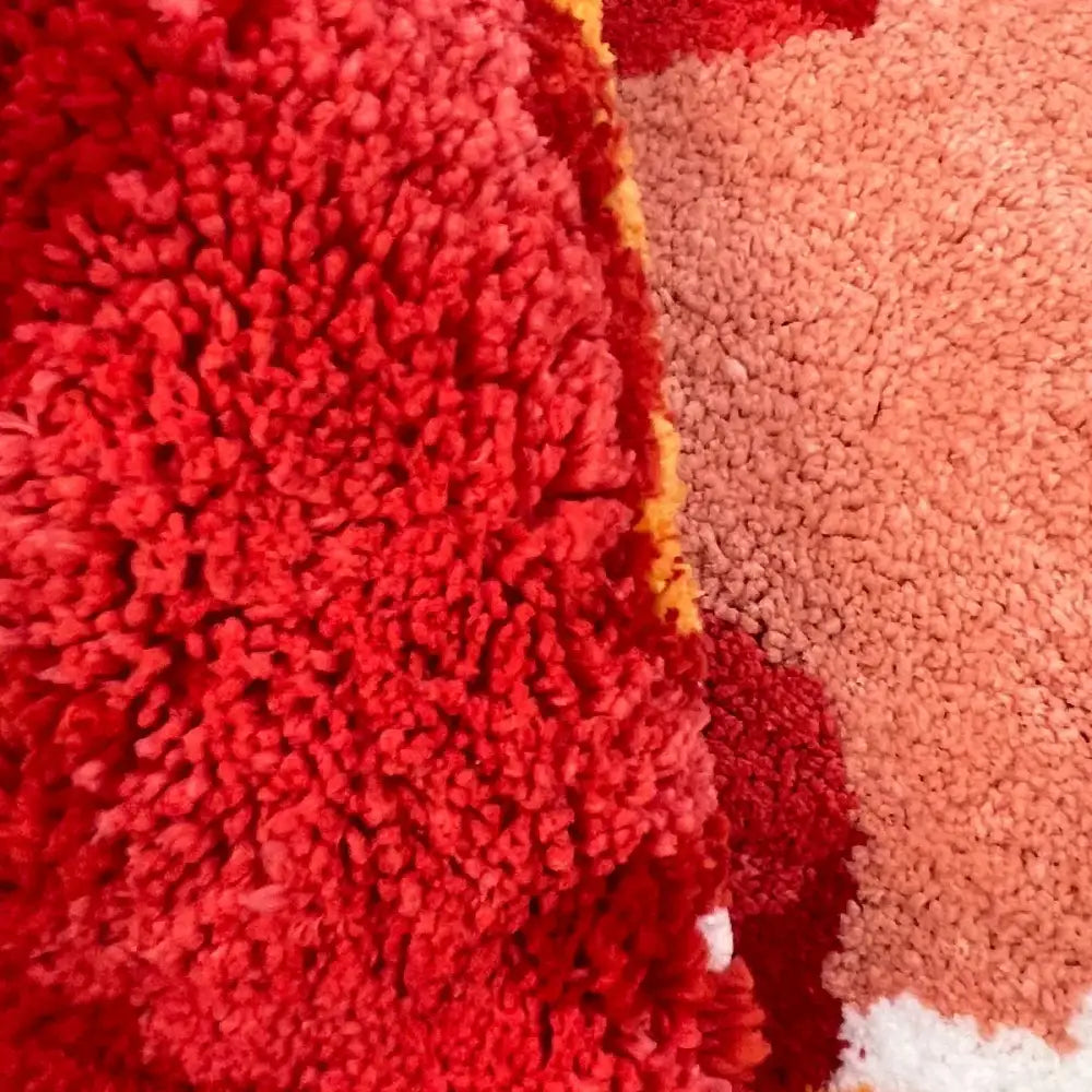 Tapis tomate en texture pelucheuse avec support caoutchouc et couleurs rouge, jaune et pêche idéal pour un coin lecture