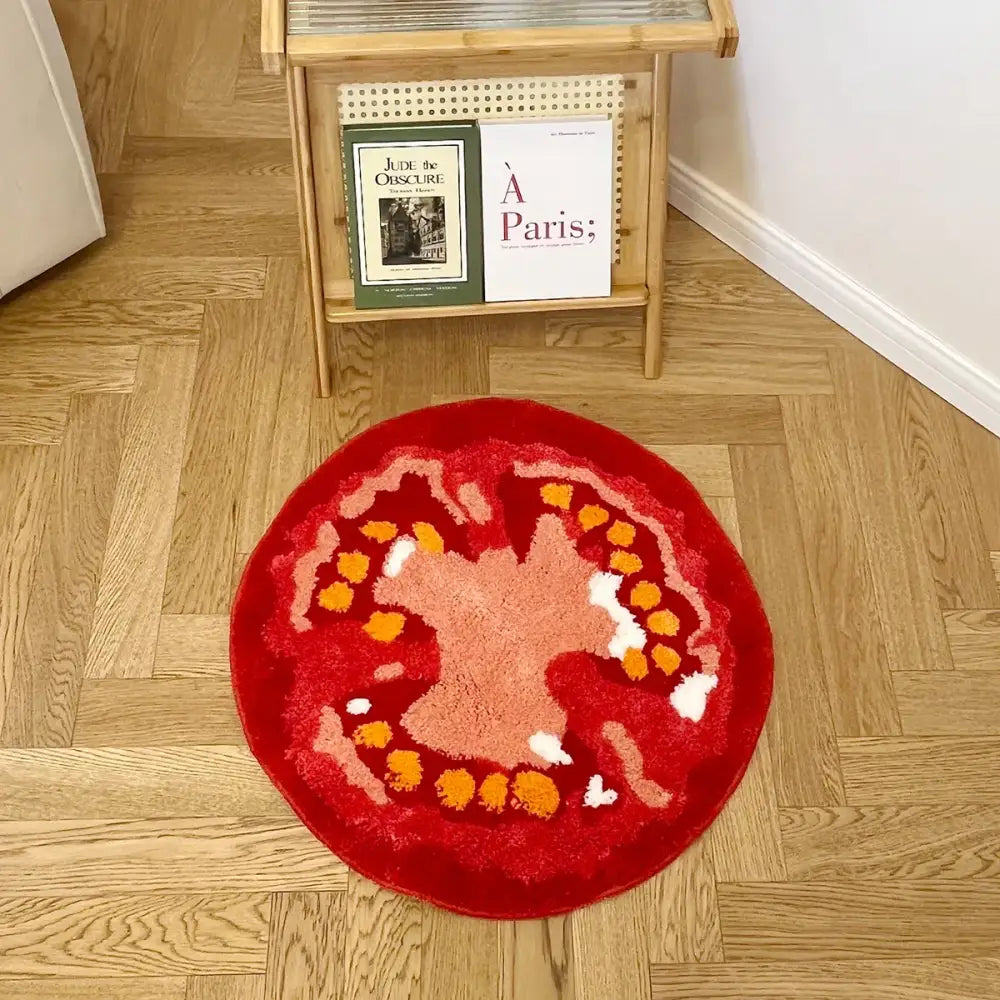 Tapis tomate rond rouge vibrant avec surface texturée en tons pêche et orange, support caoutchouc idéal pour coin lecture