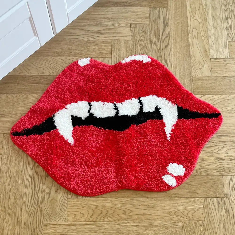 Tapis de bain lèvres de vampire rouge avec crocs blancs et contours noirs, matériau moelleux.