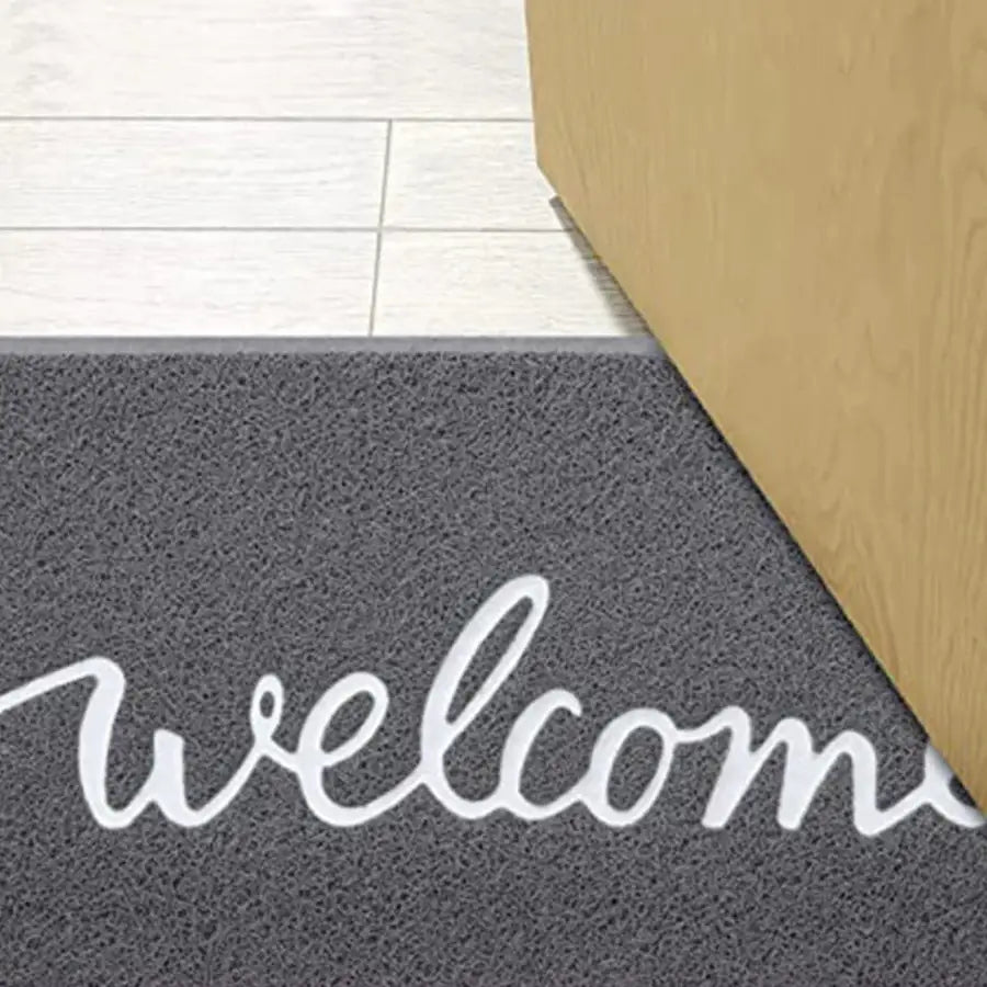 Paillasson de bienvenue avec texte cursif blanc sur fond gris, fabriqué en matériau en caoutchouc durable.